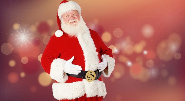 Man in Santa costume with white beard and red suit against festive blurred background with lights