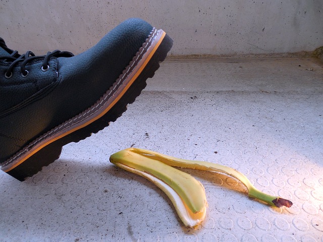 Boot stepping on a banana peel on concrete ground